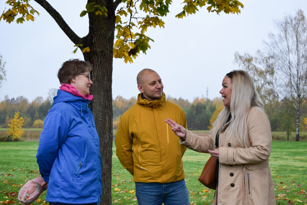 kolme ihmistä keskustelee Rantapuistossa